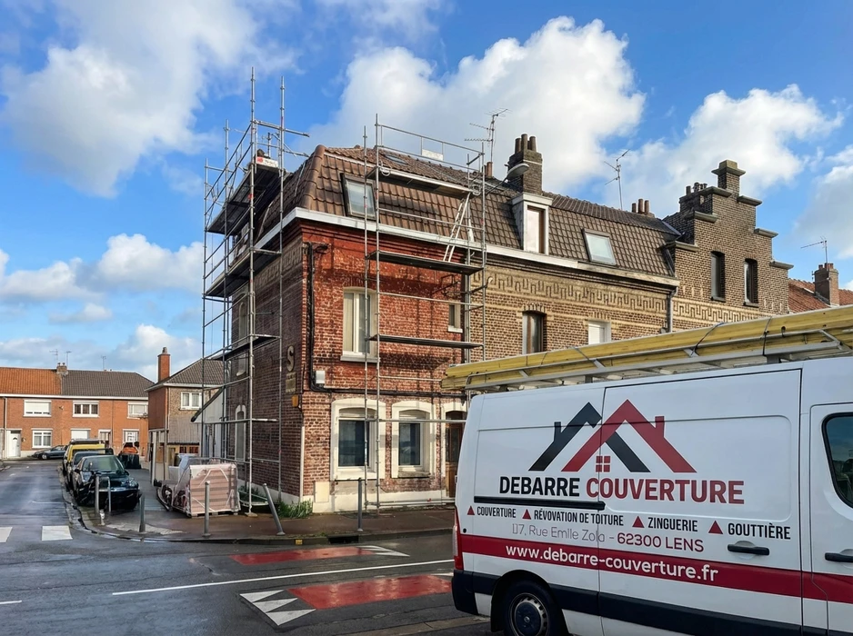 Chantier de réfection de toiture sur maison bourgeoise en briques rouges, échafaudage tubulaire multidirectionnel installé en façade